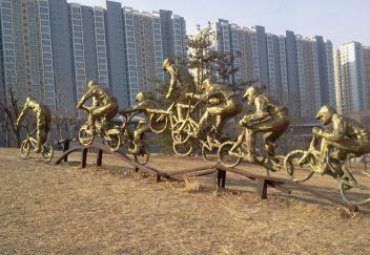 公園擺放玻璃鋼仿銅騎自行車(chē)人物雕塑